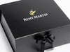 Black gift box with Rémy Martin logo and a black ribbon on a white background