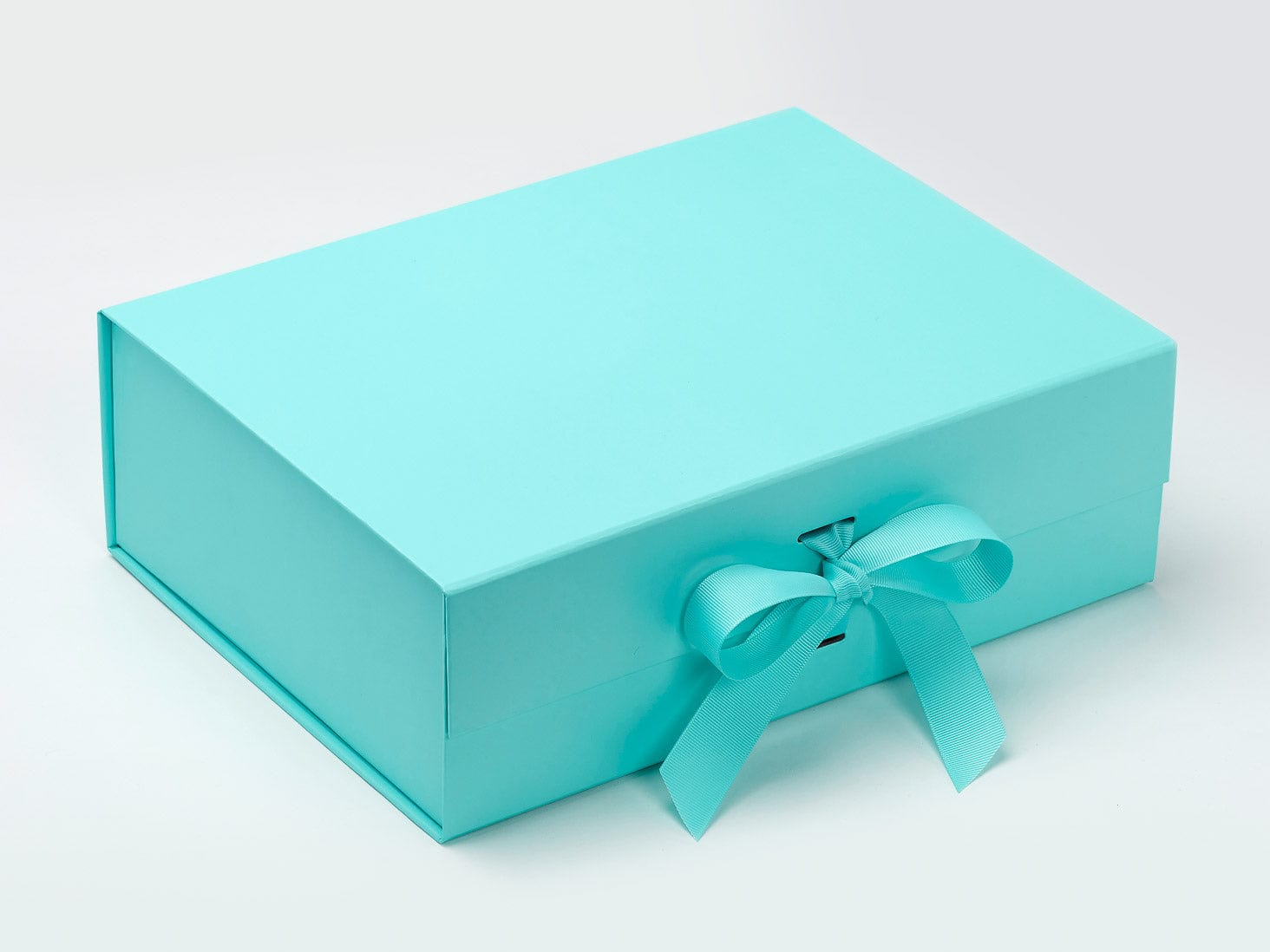 Turquoise gift box with a bow on a white background