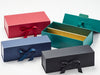 Four gift boxes in red, blue, green, and black with ribbons on a white background