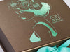 Bronze Folding Gift Box with Custom Turquoise Foil Logo and Tropical Ribbon